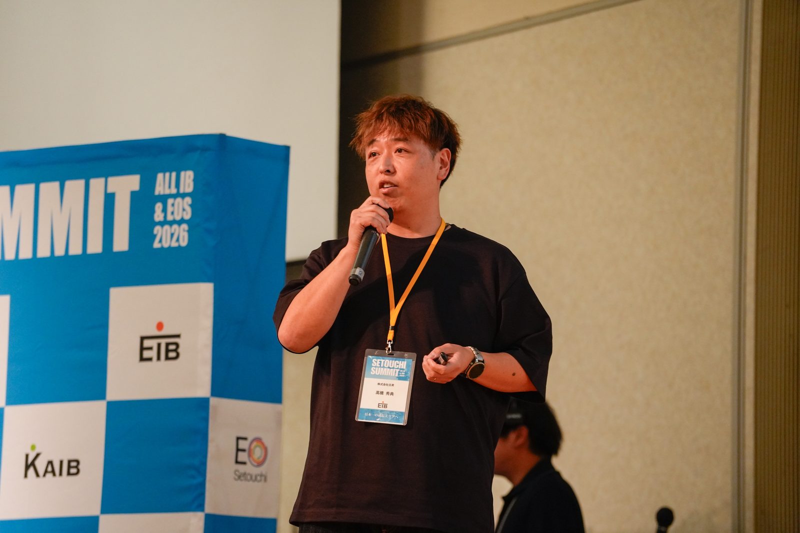 SETOUCHI SUMMITのバナーを背に、マイクを持って話す登壇者