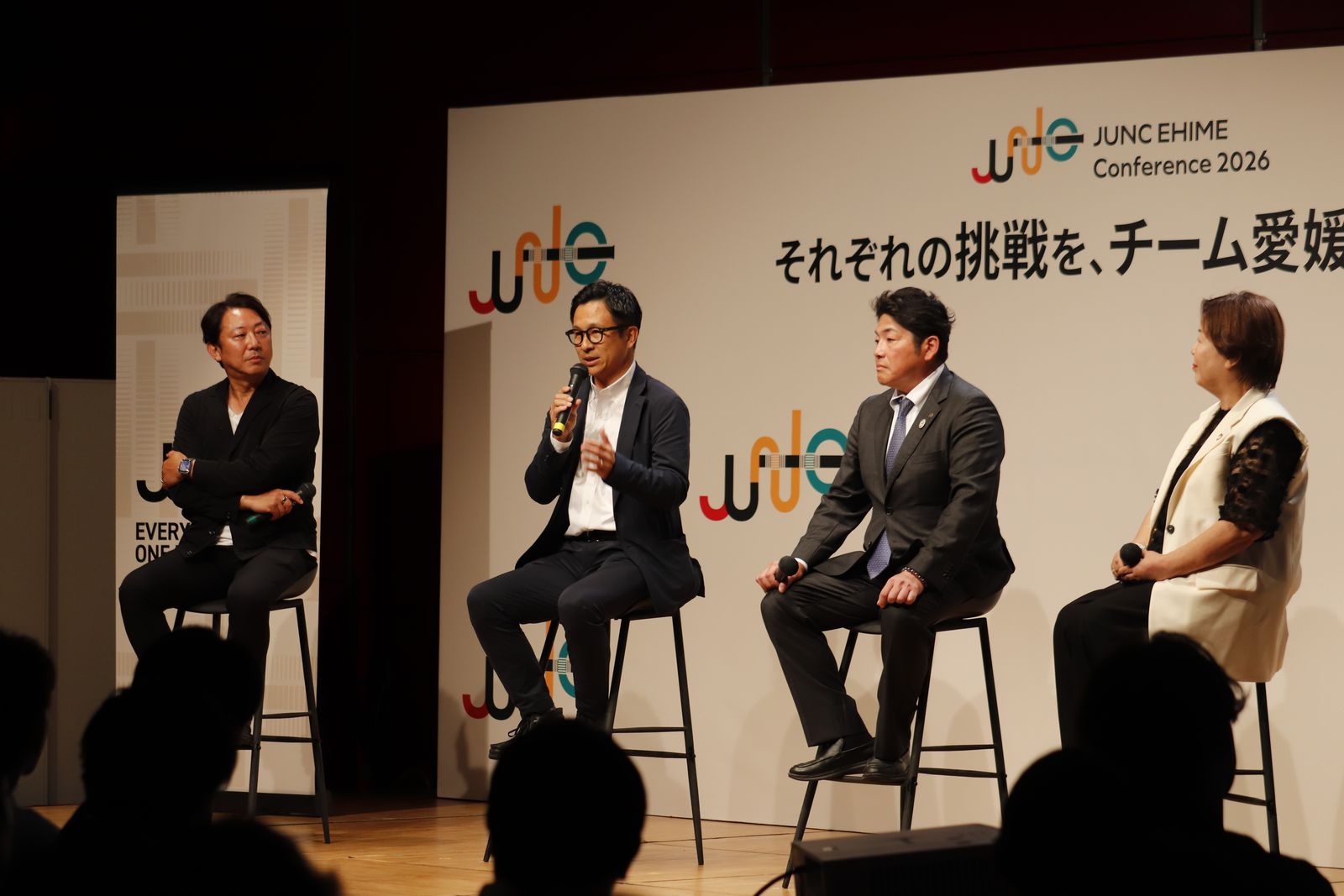 壇上に並んで座り、マイクを持って議論する登壇者4名